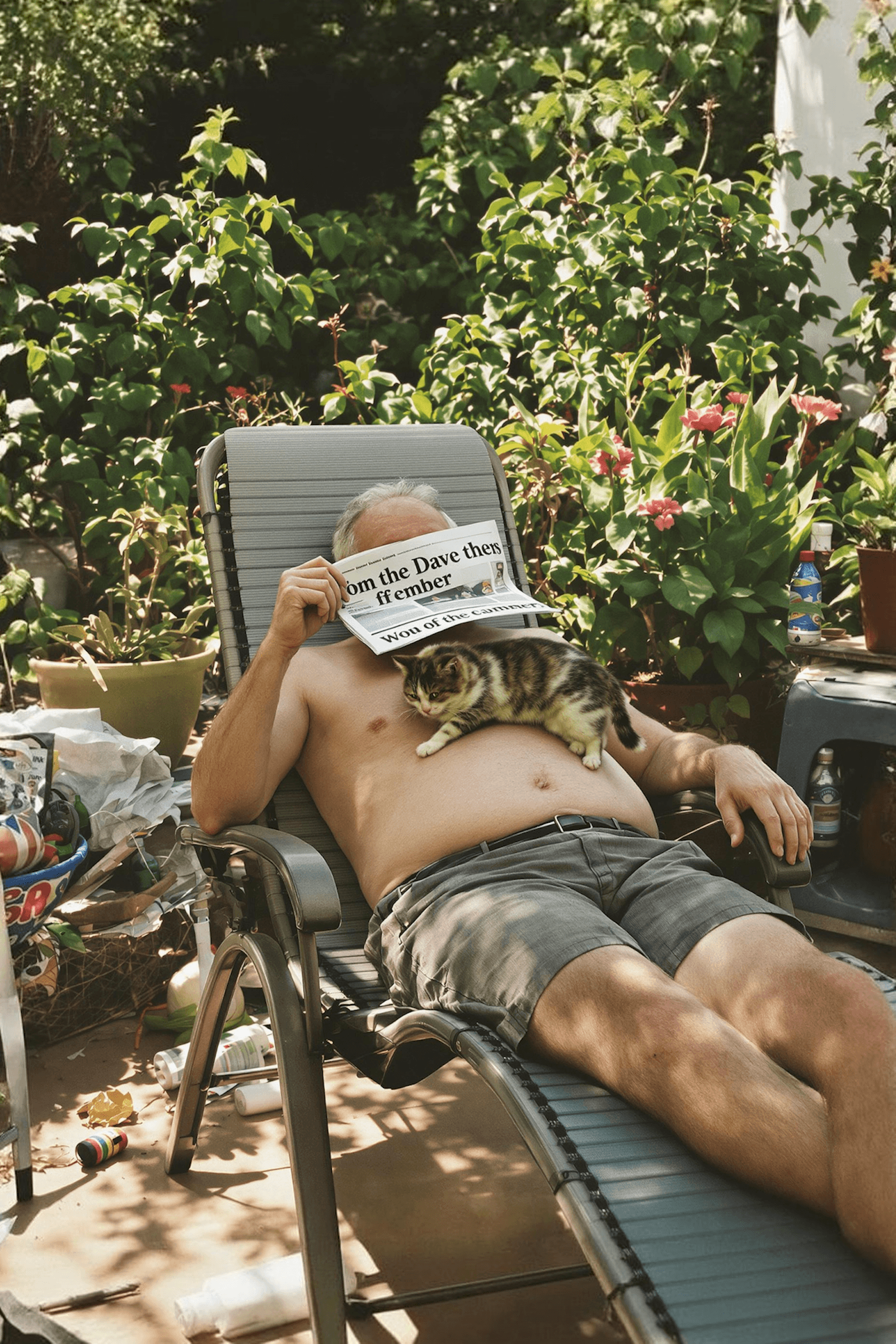 A person relaxing outdoors reading a newspaper